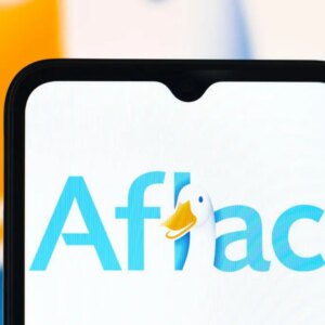 Aflac duck logo on a phone screen in front of a bigger image of the logo.