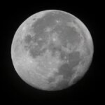 A full moon against an inky black space backdrop.