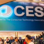 A large CES banner above a room full of people and an escalator.