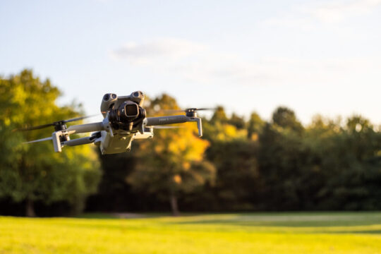 DJI Mini 5 Pro Lightweight Camera Drone in Flight over Green Field