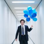 Mark Scout (Adam Scott) carries balloons down a liminal hallway in Severance season 2