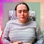 A person with a a gray striped sweater lying on an acupressure mat and pillow surrounded by Taylor Swift album covers.