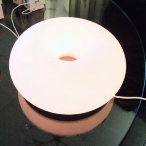 Ikea's glowing smart lamp and various devices on a table.