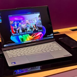 A laptop with a slightly swiveled screen sitting on a deskmat.