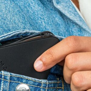 The NIMA Gluten Sensor being put in a denim jacket pocket.