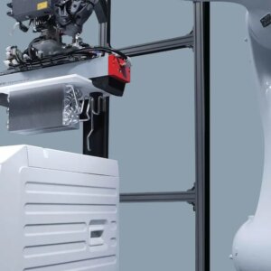 A white robotic arm lifts a component out of a white washer-dryer.