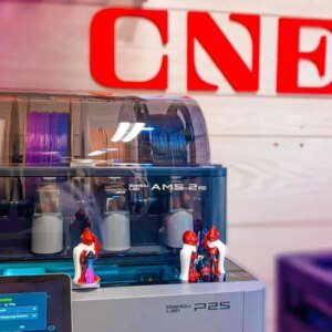 A grey printer with colored filament inside it with the CNET logo in the background