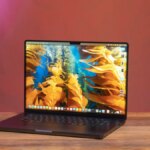 An Apple MacBook Pro 16 M4 sits open on a table.