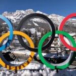 milan cortina olympic rings with snowy mountain in the background in Italy