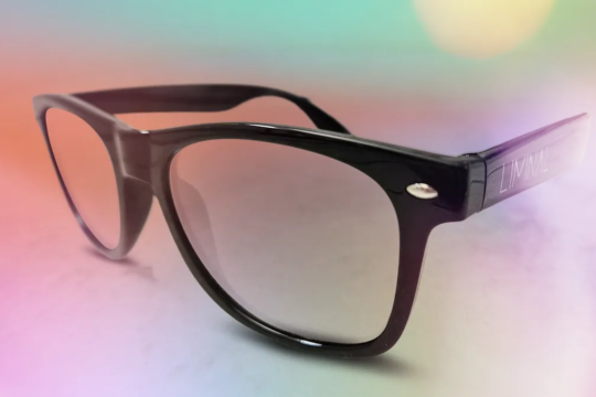 A photo of a pair of XR glasses from the company Liminal Space, on a colorful neon background